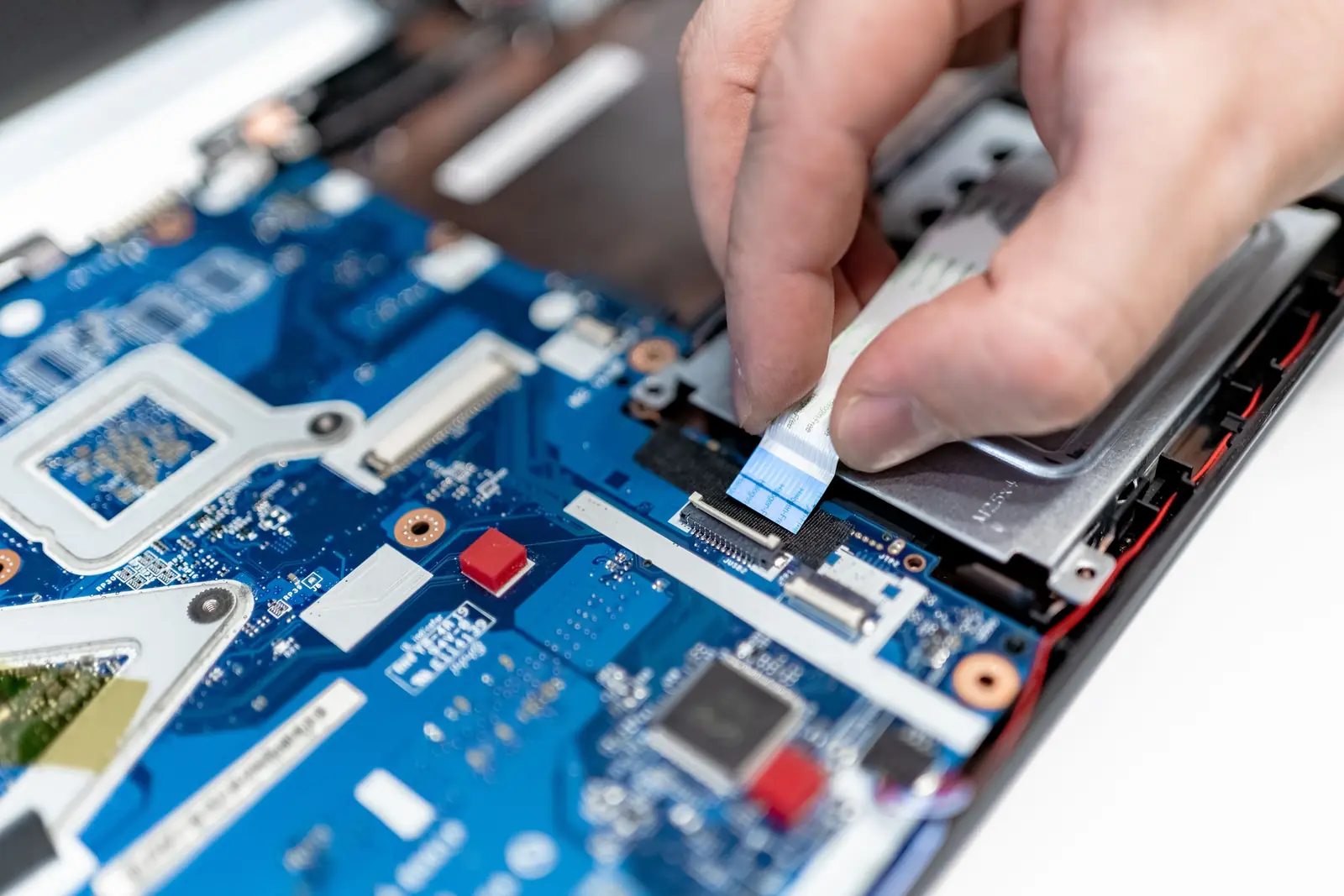 Technicien God-info réparant la carte mère d'un ordinateur portable